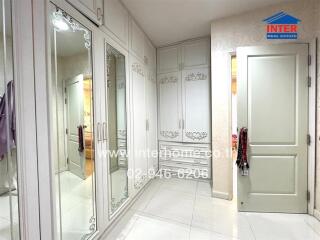 Well-lit bedroom with mirrored wardrobe and white furniture