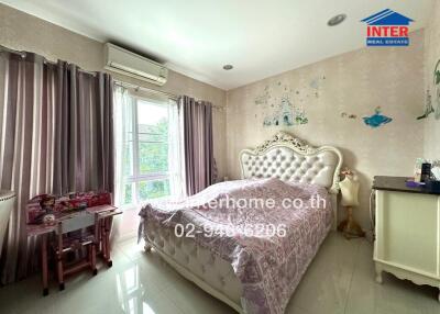 Spacious and well-lit bedroom with a large bed and decorated walls