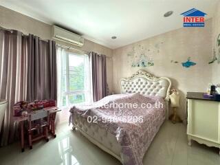 Spacious and well-lit bedroom with a large bed and decorated walls