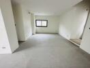 Spacious empty living room with window and staircase