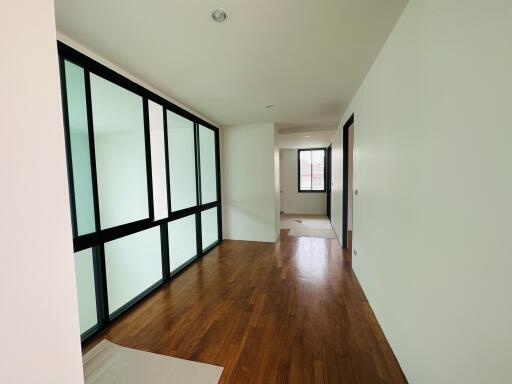 Bright hallway with wooden flooring and modern glass panel doors