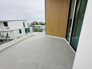 Modern balcony with glass railing and wooden accent wall