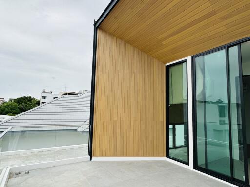 Modern balcony with wooden wall and sliding glass doors