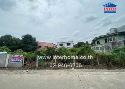 Exterior view of a vacant land plot with surrounding buildings