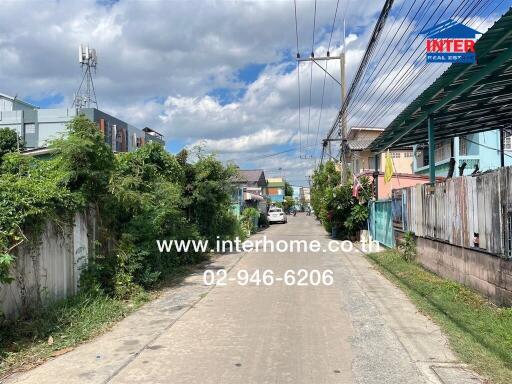 Street view of residential area with clear skies and telephone number displayed