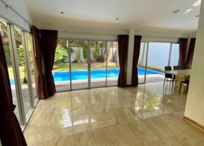 Spacious living room with large windows and view of the pool