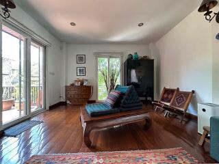 Spacious living room with large windows and wooden floors