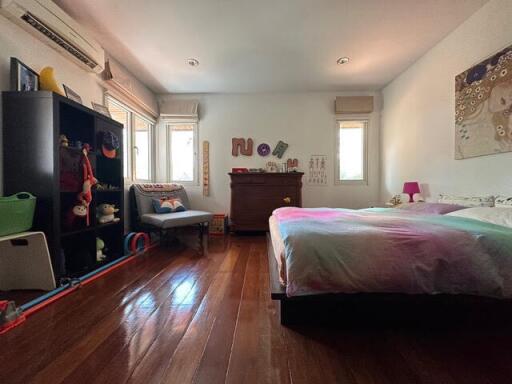 Spacious bedroom with wooden flooring and modern furnishings