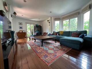 Spacious and well-lit living room with large windows and modern furnishings