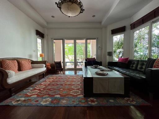 Spacious and well-lit living room with comfortable seating and large windows