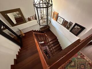 Elegant wooden staircase with decorative elements and hanging light fixture