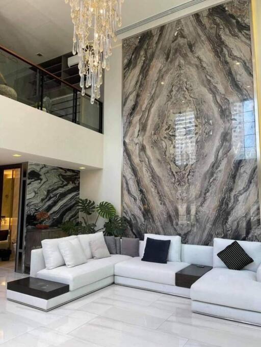 Modern living room with a large marble accent wall and white sectional sofa