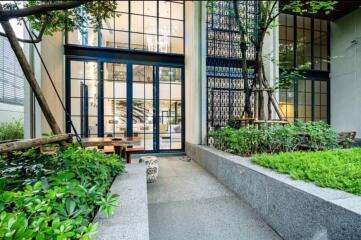 Outdoor walkway leading to a modern building entrance with large glass doors