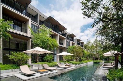 Modern apartment complex with outdoor pool and loungers