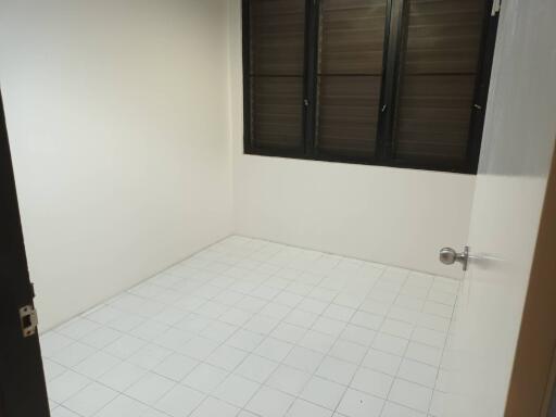 Empty bedroom with tiled floor and shuttered windows