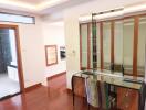 Bright bedroom with wooden floor, mirrored vanity table, built-in closet, and natural light