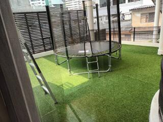 Outdoor area with artificial grass and a trampoline