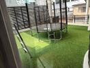 Outdoor area with artificial grass and a trampoline