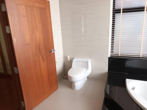 Bathroom with toilet, sink, and wooden door