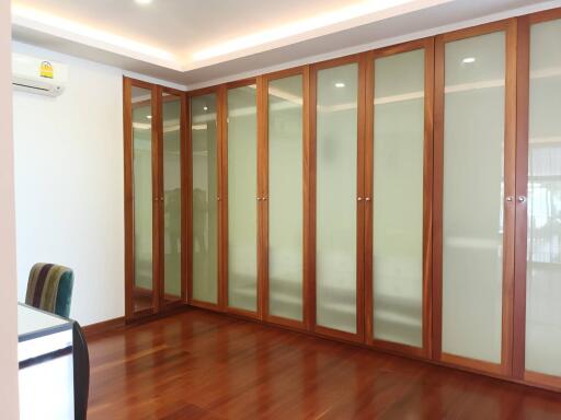 Bedroom with large wooden wardrobe and hardwood floor