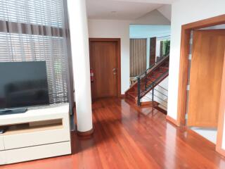 Living area with hardwood floors and staircase