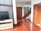 Living area with hardwood floors and staircase