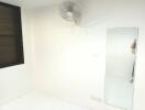 Minimalist bedroom with wall-mounted fan and mirror