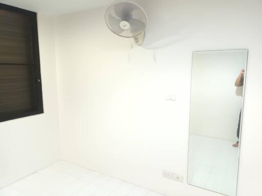 Minimalist bedroom with wall-mounted fan and mirror