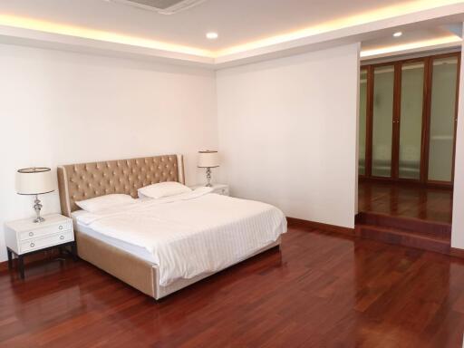 Spacious bedroom with modern furnishings and wooden flooring