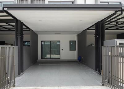 Covered carport area with a view of the building entrance