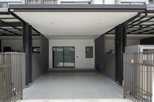 Covered carport area with a view of the building entrance