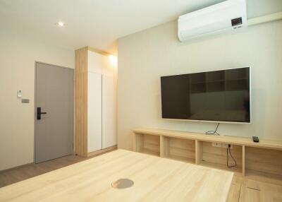 Modern living room with a wall-mounted TV and air conditioning unit