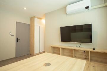 Modern living room with a wall-mounted TV and air conditioning unit