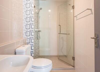 Modern bathroom with glass shower and patterned wall tiles