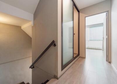 Interior hallway with view of stairs and a sliding glass door.