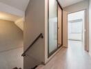 Interior hallway with view of stairs and a sliding glass door.