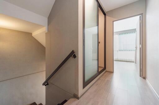 Interior hallway with view of stairs and a sliding glass door.