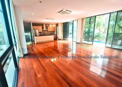 Spacious living room with wooden flooring and modern kitchen