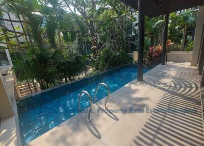 Outdoor pool area with lush greenery