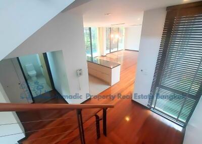 Spacious open-plan living area with wooden flooring and large windows