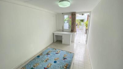 Small bedroom with a single mattress and writing desk