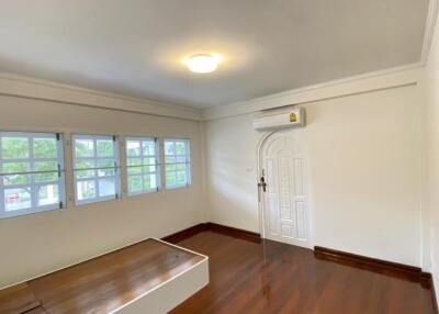 Bright bedroom with wooden flooring and multiple windows