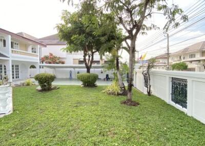 Spacious garden with trees and surrounding fence