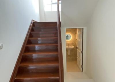 Staircase and view of a hallway with natural lighting.