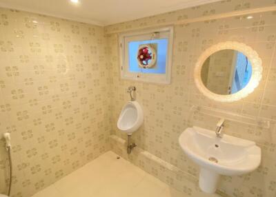 Bathroom with urinal, sink, and decorative tiles