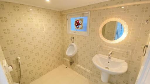 Bathroom with urinal, sink, and decorative tiles