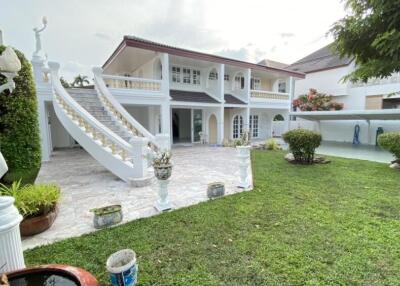 Elegant two-story house with a manicured garden and statues