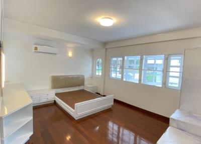 Spacious and bright bedroom with hardwood floors, air conditioning, and large windows