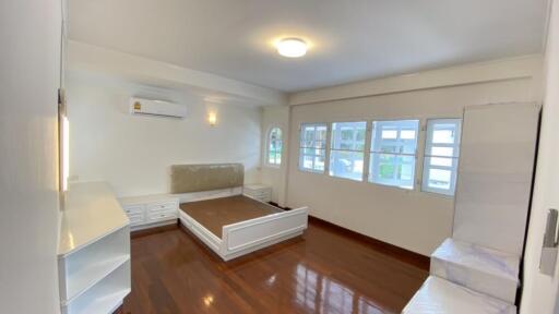 Spacious and bright bedroom with hardwood floors, air conditioning, and large windows