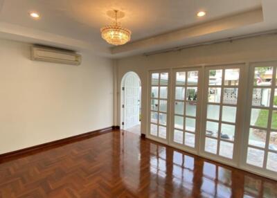 Spacious living room with wooden flooring and large windows